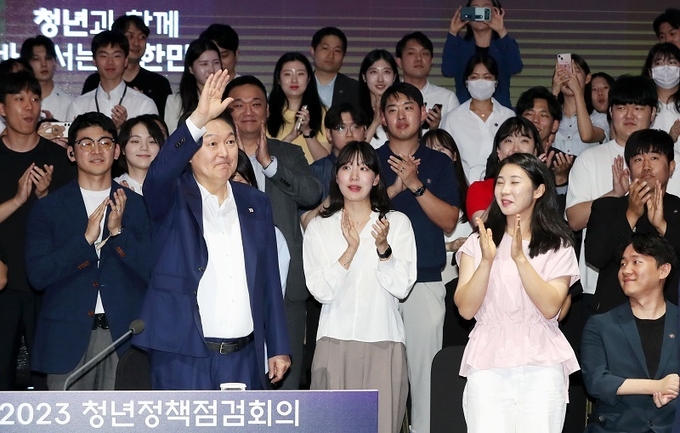 윤석열 대통령이 6일 서울 서초구 플로팅아일랜드 컨벤션홀에서 열린 청년정책 점검회의에서 손을 들어 인사하고 있다.