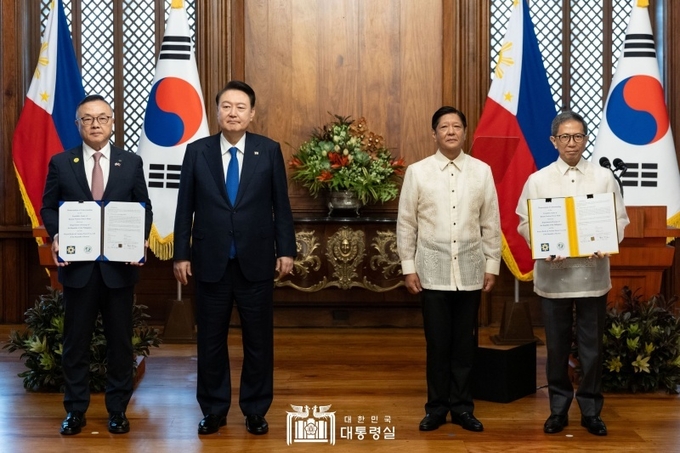 황주호 한국수력원자력 사장과 라파엘 로띨리야 필리핀 에너지부 장관이 7일 오전(현지시간) 필리핀 마닐라 말라카냥 대통령궁에서 윤석열 대통령과 페르디난드 마르코스 필리핀 대통령이 임석한 가운데 한·필리핀 바탄 원전 건설 재개 타당성 조사 협력에 관한 양해각서(MOU)를 교환한 뒤 기념촬영을 하고 있다.(대통령실 홈페이지)