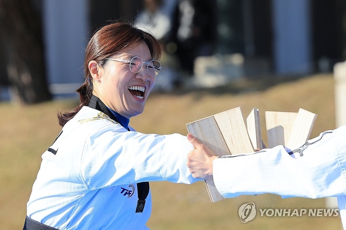 【장미란 차관의 송판 격파】 장미란 문화체육관광부 제2차관이 10일 오후 서울 종로구 청와대 대정원에서 한국체육대학교 태권도 시범단이 펼친 '위대한 태권도 in 청와대'를 관람한 뒤 송판 격파 체험을 하고 있다. 2024.11.11./연합뉴스