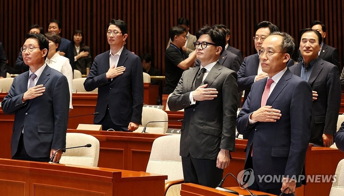 【국기에 경례하는 한동훈 대표와 추경호 원내대표】 (서울=연합뉴스) 국민의힘 한동훈 대표(앞줄 오른쪽 두번째)와 추경호 원내대표 등 참석한 의원들이 4일 오전 국회에서 열린 의원총회에서 국기에 경례하고 있다. 2024.11.14. / 연합뉴스