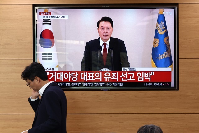 12일 오전 정부세종청사 농림축산식품부 기자실에서 열릴 예정이던 브리핑이 윤석열 대통령의 담화로 잠시 지연되고 있는 가운데 공무원들과 기자들이 TV를 통해 담화 내용을 지켜보고 있다. 2024.12.13. / 연합뉴스