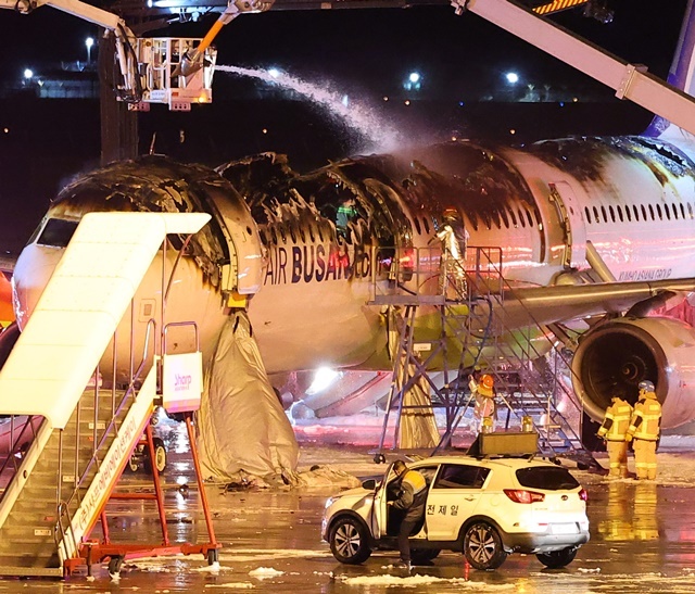 28일 오후 김해공항 계류장에서 승객 170명과 승무원 6명을 태우고 이륙을 준비하던 홍콩행 에어부산 항공기 BX391편 내부에서 불이 나 소방대원들이 진화 작업을 하고 있다. 화재는 1시간 16분 만에 완전히 진압됐고 승객 170명(탑승 정비사 1명 포함), 승무원 6명 등 모두 176명은 비상 슬라이드로 모두 탈출했다. 2025.1.29. / 연합뉴스
