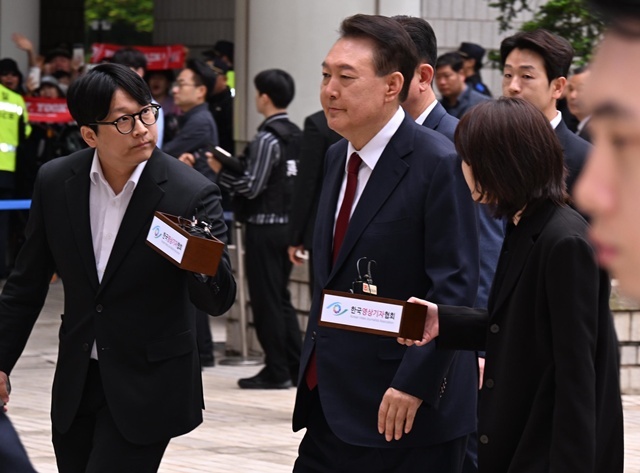 윤석열 전 대통령이 19일 서울 서초구 중앙지방법원에서 열린 내란 우두머리 혐의, 직권남용 권리행사방해 혐의 사건 4차 공판에 출석, 취재진의 질문을 받으며 이동하고 있다. 2025.5.26. / 연합뉴스