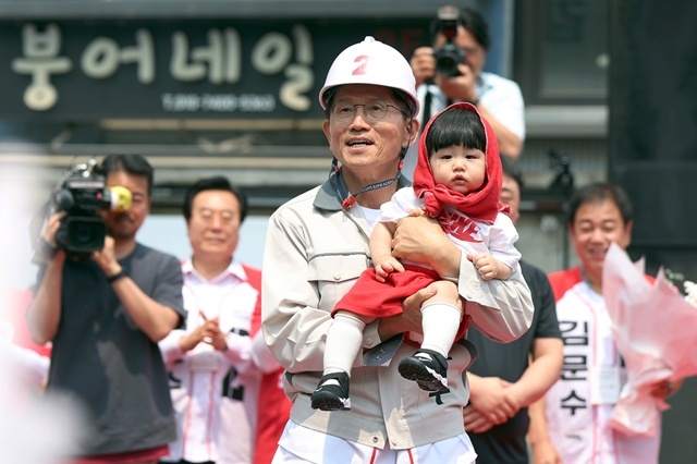 국민의힘 김문수 대선후보가 28일 오전 경남 창원시 성산구 상남동 분수광장에서 한 아이를 안고 있다. 2025.5.28. / 연합뉴스