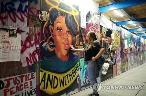 경찰 총기 피격 사망' 테일러 얼굴 벽화 어루만지는 미 여성 / 연합뉴스