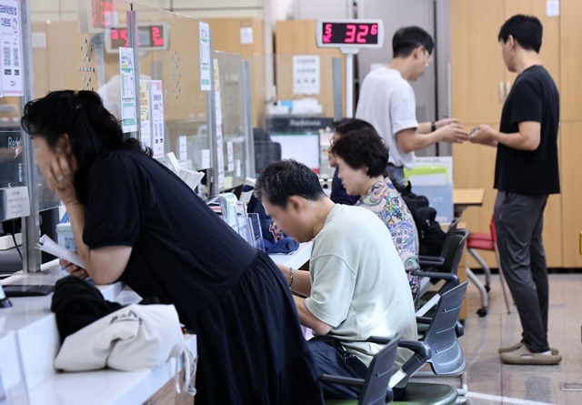 국가정보자원관리원(국정자원) 대전 본원 화재로 전산망 마비 사태가 나흘째 이어진 지난달 29일 서울의 한 주민센터에서 시민들이 업무를 보고 있다. / 연합뉴스