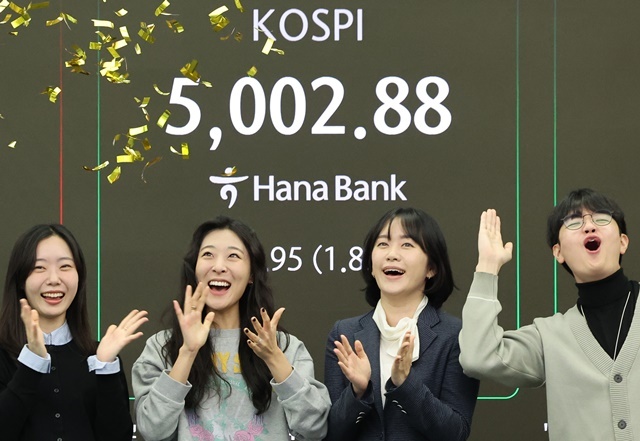 22일 오전 서울 중구 하나은행 딜링룸에서 딜러들이 코스피가 장중 5,000을 넘어서자 기뻐하고 있다. / 연합뉴스