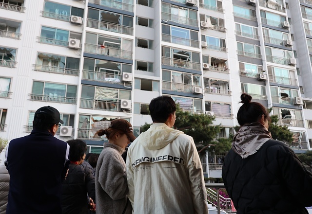 13일 오전 청주시 흥덕구 봉명동의 한 아파트 주민들이 폭발 사고 여파로 깨진 창문을 바라보고 있다. / 연합뉴스