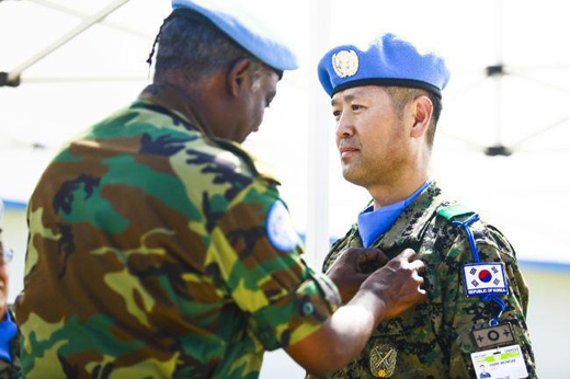 UNMISS 요하네스 테스파마리암 총사령관이 지난 4일 남수단 현지에서 열린 유엔 메달 퍼레이드 행사에서 박원대(대령) 한빛부대장에게 유엔기념메달을 달아주고 있다. (사진=국방일보)